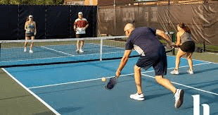 Professional pickleball game action with players at the net
