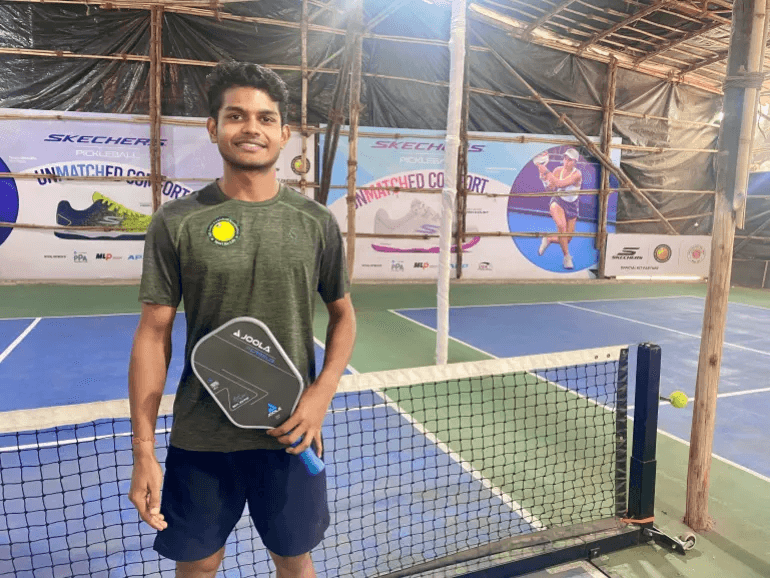 Pickleball player with paddle on court